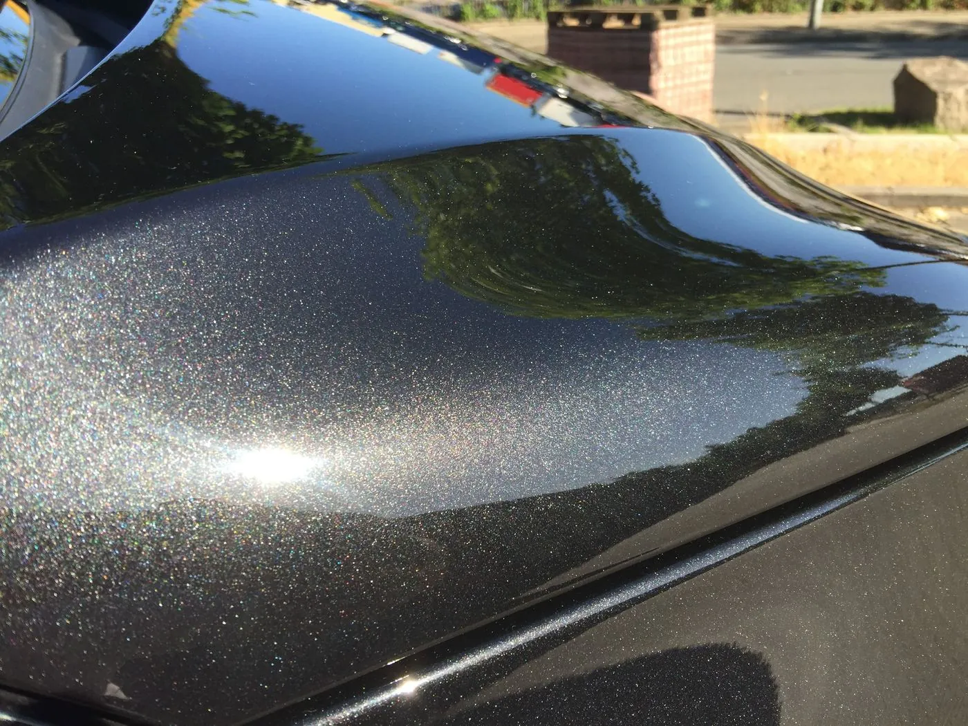 Cofre negro con brillo metálico tras el pulido de autos con máquina orbital